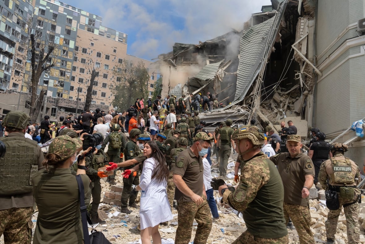 Rescuers, volunteers and medical workers clean up the rubble and search victims after Russian missile hit the country's main children hospital Okhmadit during massive missile attack on many Ukrainian cities in Kyiv, Ukraine, Monday, July 8, 2024.