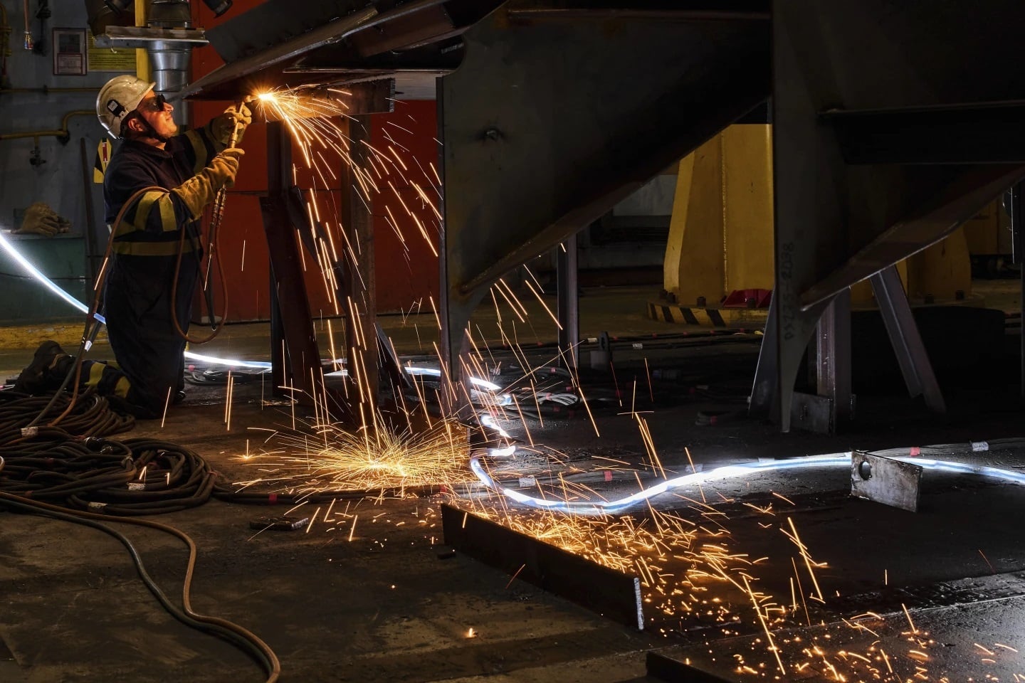 A worker welds a section of the F-111 class frigate's fuselage at a workshop in the Navantia shipyard in Ferrol, northern Spain, on April 10, 2025.