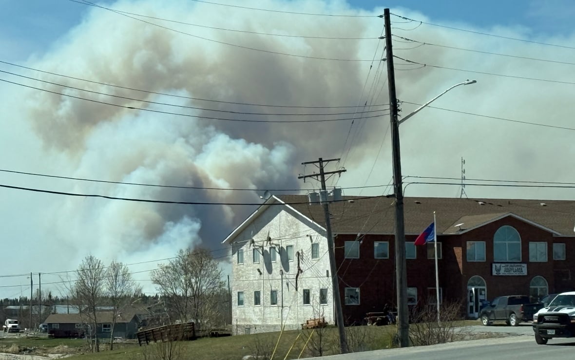 A plume of smoke billows from behind a building in Pimicikamak Cree Nation.