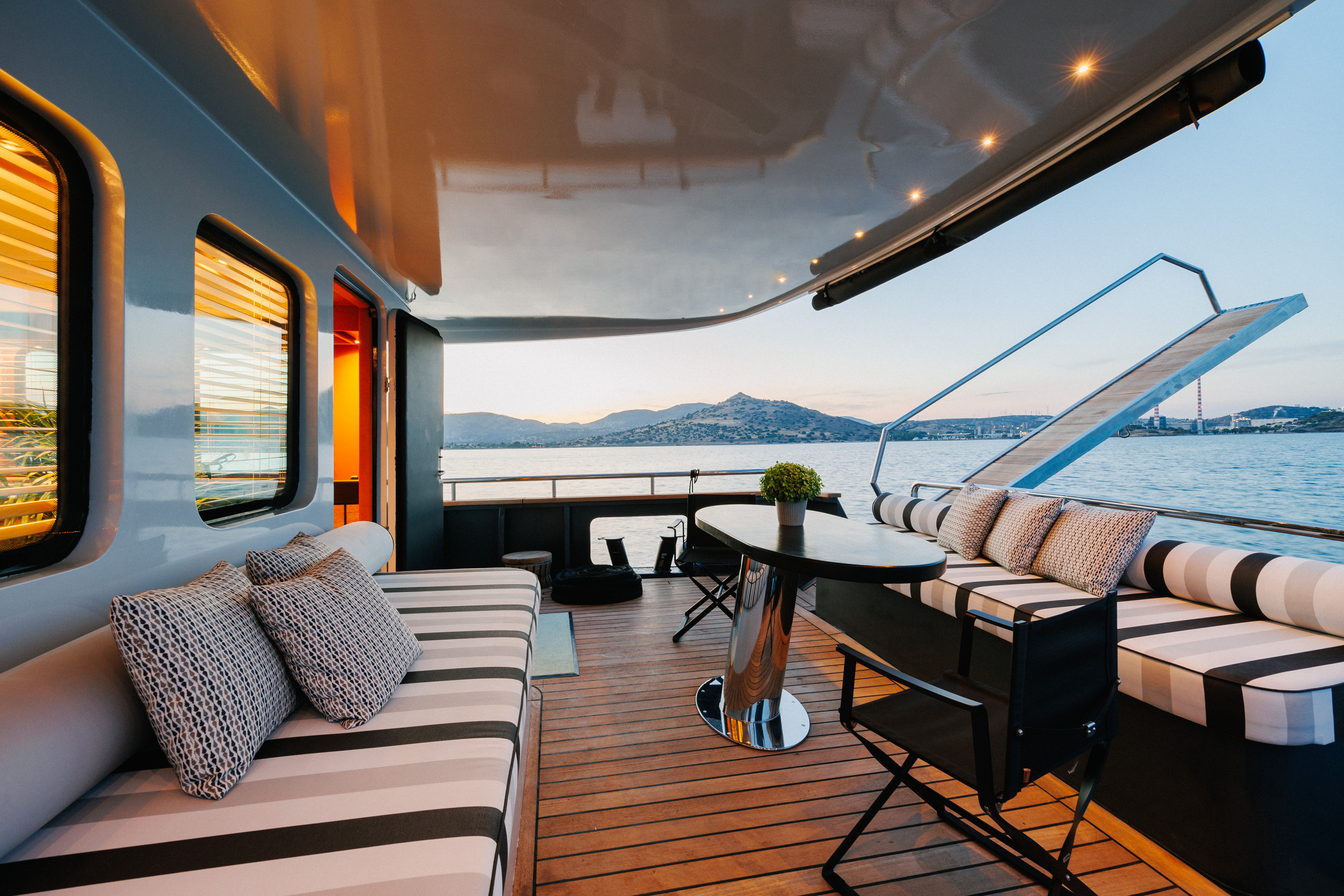 The deck of the Gemaya yacht, showing seating and a table.