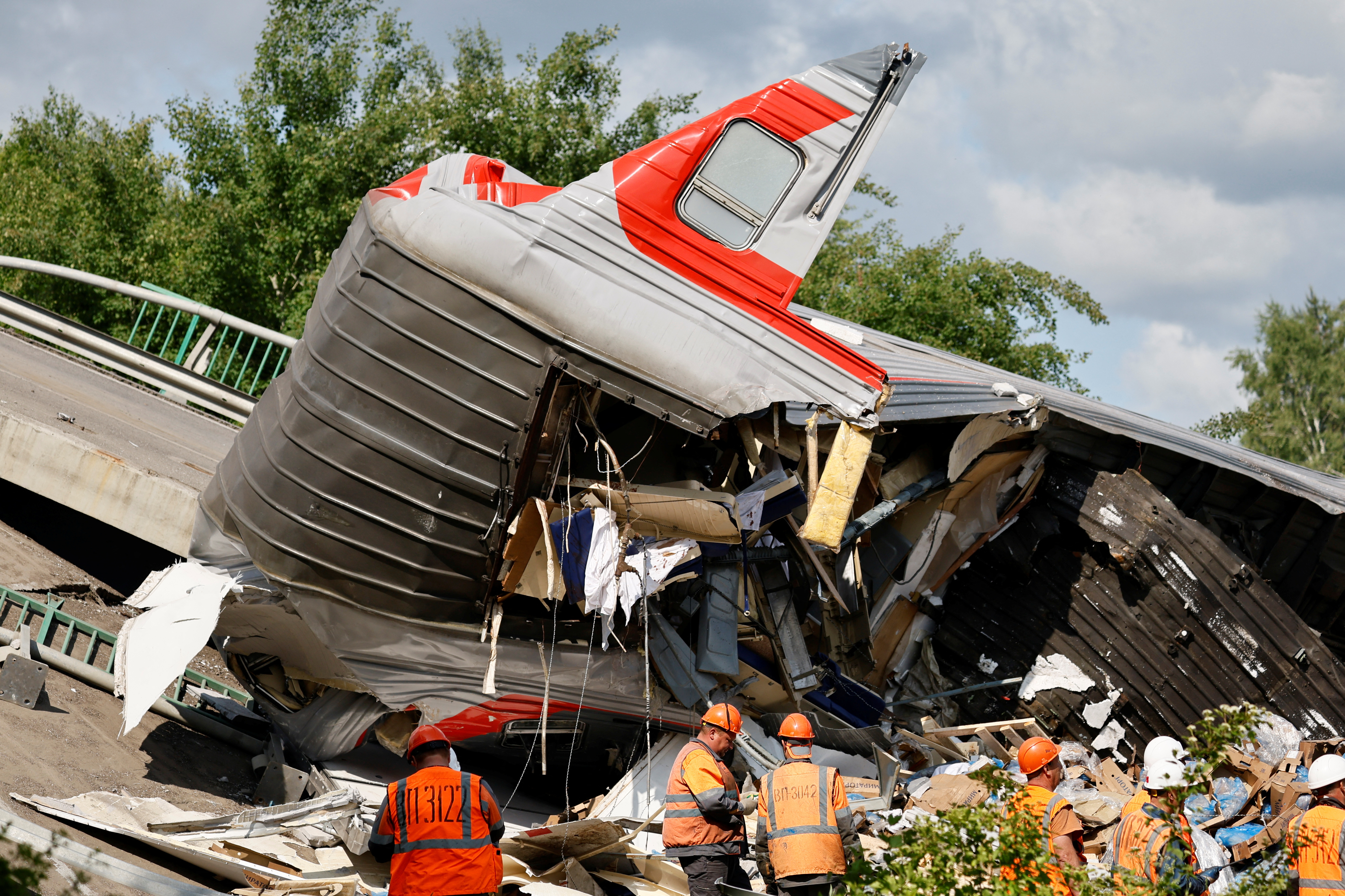 Aftermath of a train derailment in Russia, with emergency personnel at the scene.