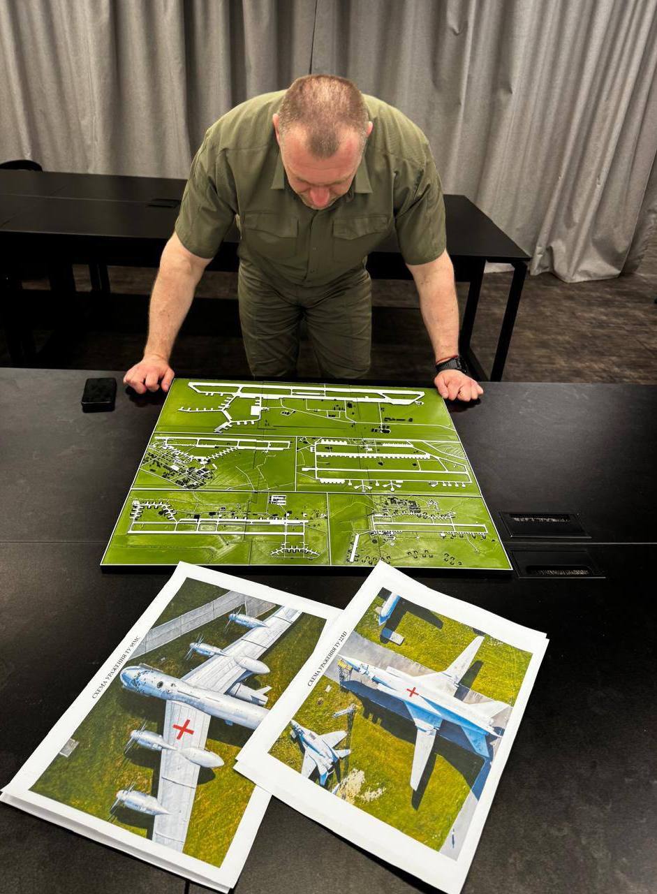 Photo of Ukraine's SBU Chief Vasyl Maliuk reviewing maps and photos of aircraft during a special operation.