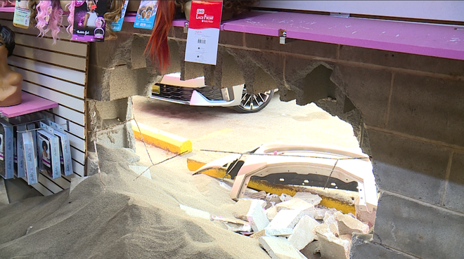 You can see the parking lot from hole left in wall of business after car smashed through it