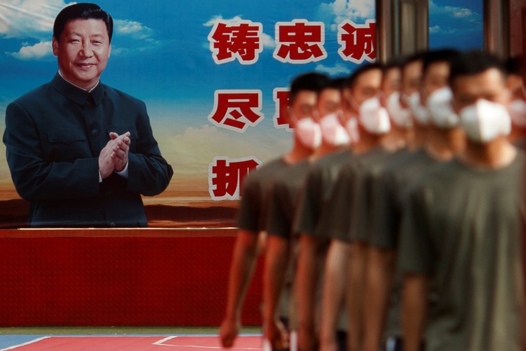 Photo: Paramilitary Police officers march in formation near a poster of Chinese President Xi Jinping at the gate to the Forbidden City on the opening day of the National People's Congress (NPC) following the outbreak of the coronavirus disease (COVID-19), in Beijing, China May 22, 2020. Credit: REUTERS/Thomas Peter