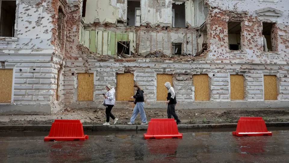 Residents walk at a street near a building damaged by Russian missile strikes, amid Russia's attack on Ukraine, in Sumy, Ukraine June 13, 2025. - Sofiia Gatilova/Reuters