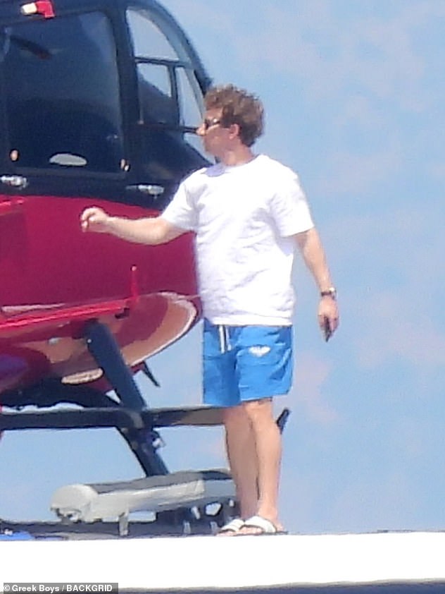 The Facebook co-founder hooped out of the striking helicopter in a white T-shirt and turquoise trunks, shielding behind a pair of shades