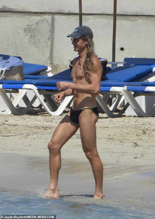 Flaunting his toned physique and six-pack abs, the flamboyant style icon confidently strolled along the sand