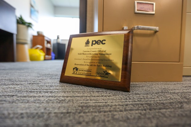 A Governor’s Award for environmental excellence rests on recycled filing...