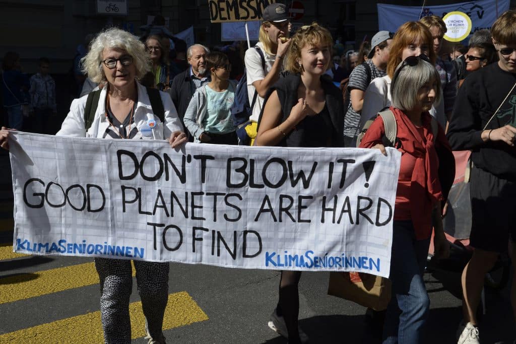KlimaSeniorinnen activists hold a sign reading 'Don't blow it! Good planets are hard to find" at a climate protest in Bern in 2019.