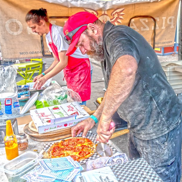 Pawel Gago is in professional pizza-maker mode as he slices...