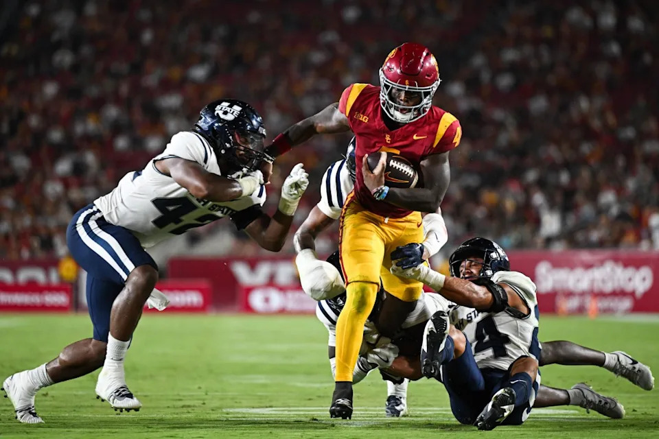 Sep 7, 2024; Los Angeles, California, USA; USC Trojans running back Woody Marks (4) runs the ball against Utah State Aggies linebacker Clyde Washington (42) during the second quarter at United Airlines Field at Los Angeles Memorial Coliseum. Jonathan Hui-Imagn ImagesJonathan Hui-Imagn Images