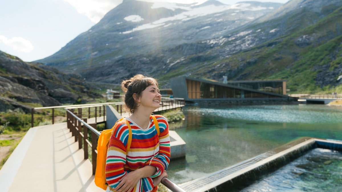 Woman on viewing platform near the river at Trollstiegen viewpoint in Norway