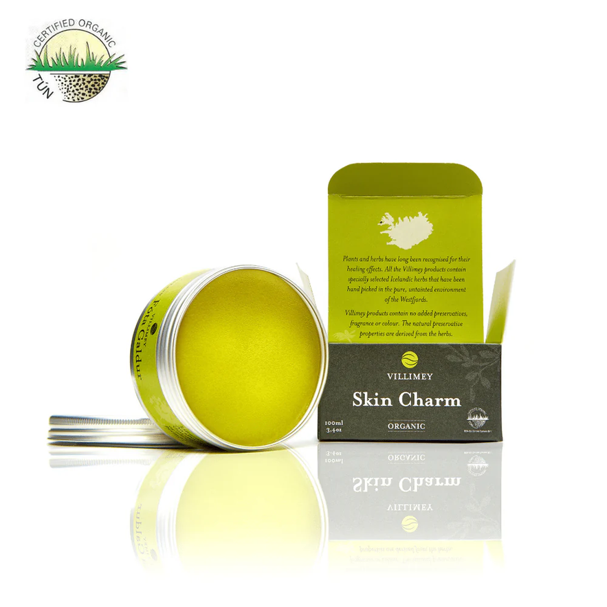 Villimey Organic Skin Charm salve, open to show its yellow balm, with its box and organic certification.