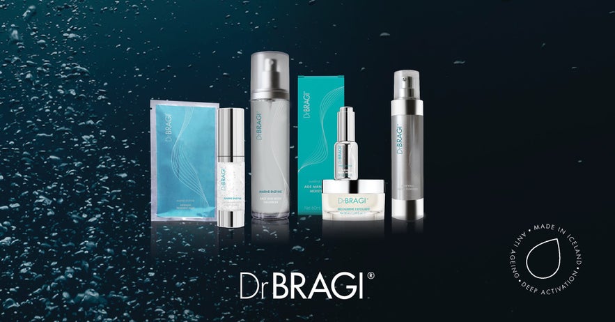 Dr. BRAGI Marine Skincare products in Iceland, including various bottles, creams, and sachets, on a dark, wet background.