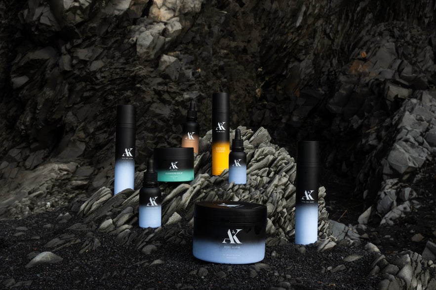 A collection of AK Pure Skin Icelandic skincare products displayed on dark volcanic rocks.