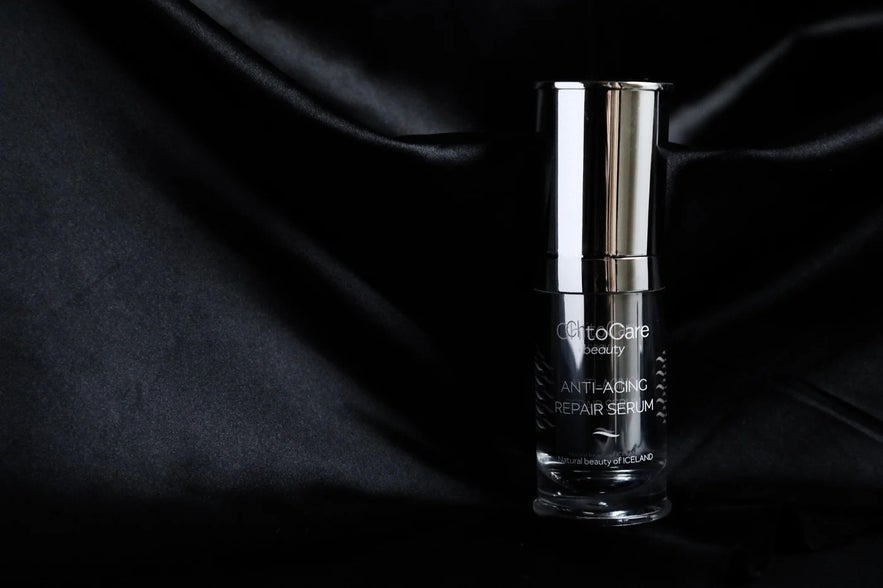 ChitoCare Beauty Anti-Aging Repair Serum bottle with a metallic top on a luxurious black satin background.