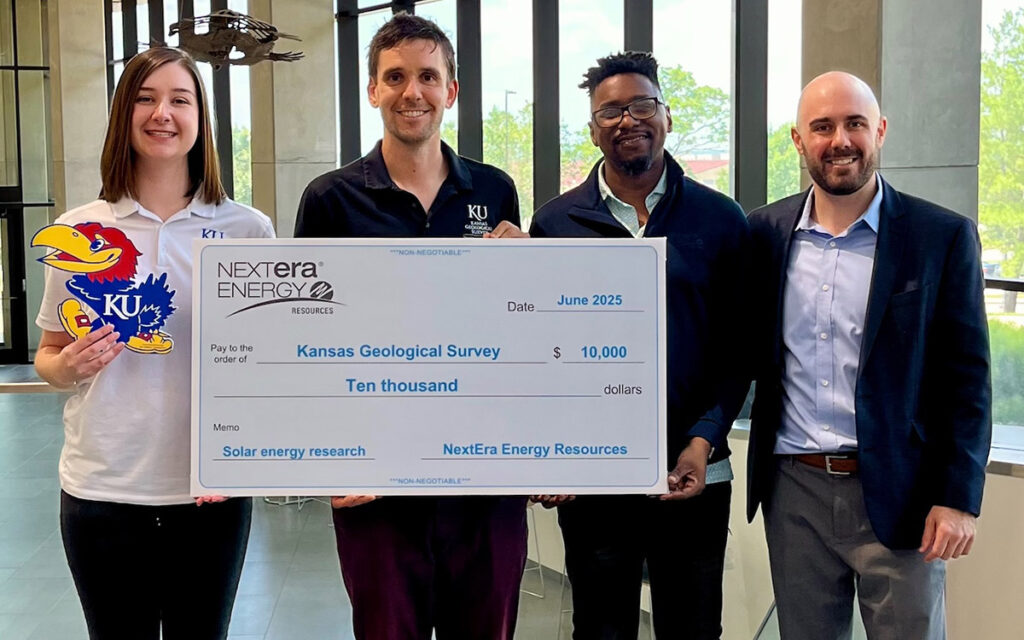 KGS staffers accept check from NextEra representatives.
