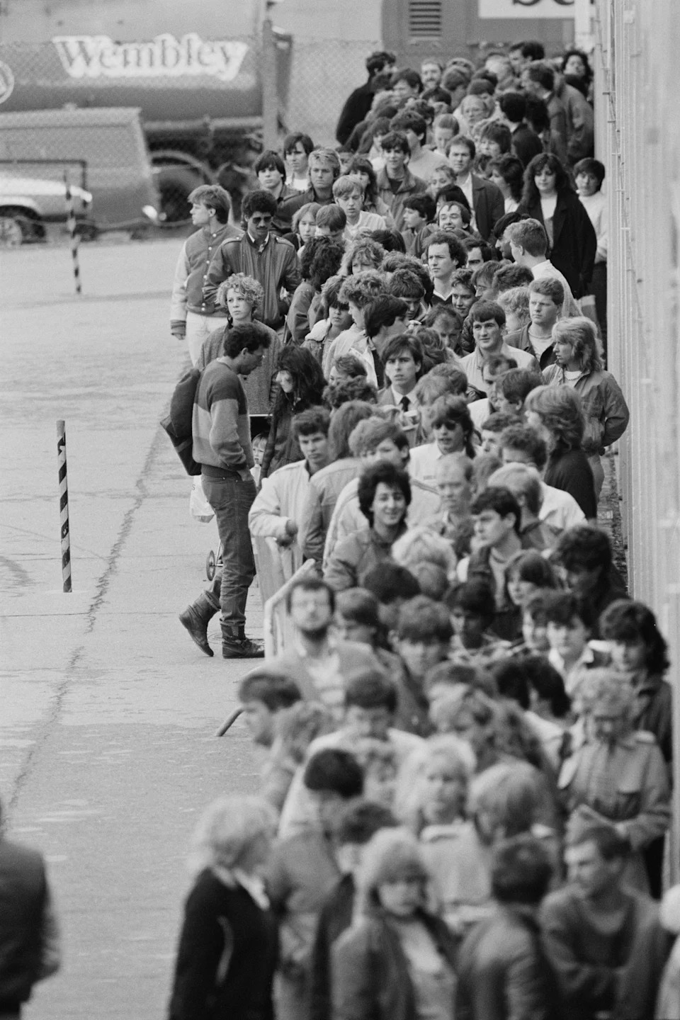 Crowds queuing at Wembley Arena in London, possibly for tickets for the upcoming Live Aid concert.