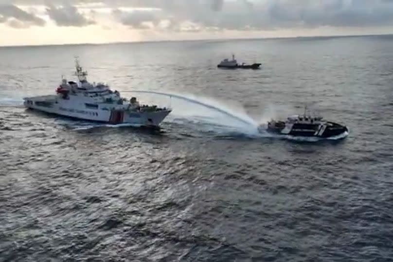A Chinese coast guard vessel, left, fires a powerful water cannon on a Philippine bureau of fisheries vessel near a disputed shoal in the South China Sea, 4 December, 2024