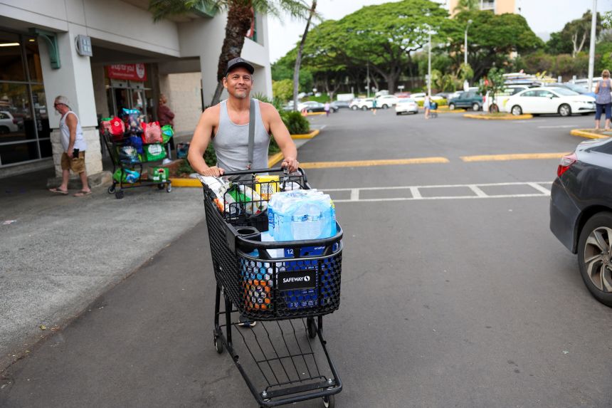 Honolulu resident Adam Jung pushes water and other supplies out of a store after authorities warned residents of the possibility of destructive tsunami waves, in Honolulu, Hawaii, on Wednesday.