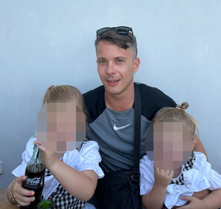 Man holding two young children.