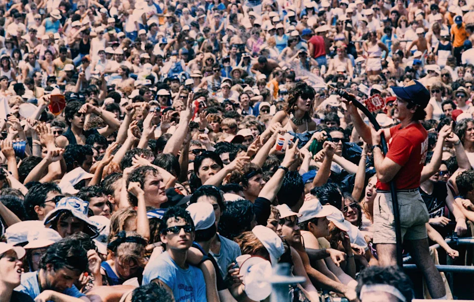 Staff member sprays water on spectators during the first Live Aid concert at the JFK Stadium, in Philadelphia on July 13, 1985.