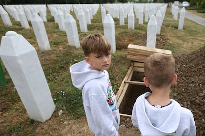 Bosnian children look at the excavated graves at the Srebrenica-Potocari Memorial Center on the occasion of the funeral for the victims of the Srebrenica genocide on Thursday in Protocari.