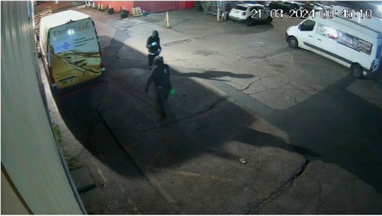 a security camera view of people walking in a carpark