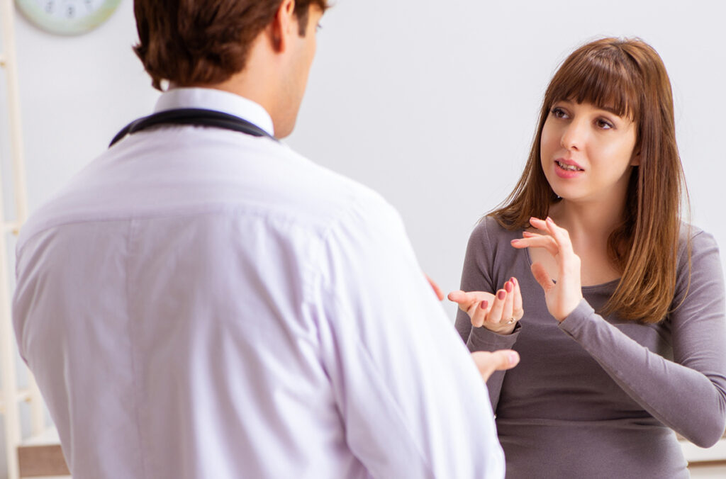 An ASL interpreter talks with a patient.