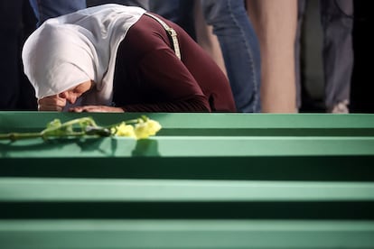 A woman cries next to the coffin with the remains of her family member, a recently identified victim of the Srebrenica genocide, in Potocari, Bosnia, Wednesday.