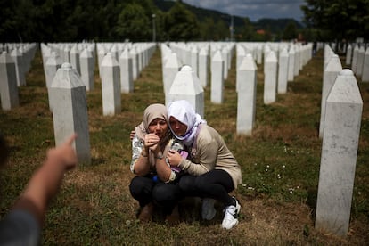 Two women mourn at the grave of their relative, a victim of the Srebrenica genocide, before the burial ceremony in Potocari, Bosnia.