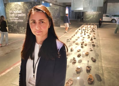 Almasa Salihovic, public relations officer at the Srebrenica-Potocari Memorial and Cemetery, posed on July 9 at the center's premises in front of the shoes worn by dozens of Bosnians to flee through the mountain of the siege on Srebrenica.