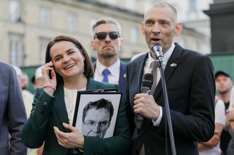WARSAW, POLAND - 2025/06/26: Belarusian democratic leader Sviatlana Tsikhanouskaya (L) laughs while listening to a speech by her husband, former political prisoner Siarhei Tsikhanouski (R), during their first joint public meeting with the Belarusian diaspora in Warsaw. Siarhei Tsikhanouski is a former political prisoner and the husband of Sviatlana Tsikhanouskaya, the democratic leader of Belarus. This is their first public meeting with the Belarusian diaspora. Tsikhanouski was sentenced to 19 years and 6 months in prison and spent over five years behind bars. On June 21, he and 13 other political prisoners were released and deported to Lithuania following the visit of Keith Kellogg, the special representative of U.S. President Donald Trump, to Belarus. (Photo by Volha Shukaila/SOPA Images/LightRocket via Getty Images)
