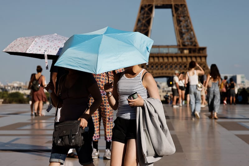 Tourists hold umbrellas to protect themselves from the sun during a heatwave at the Trocadero square, in Paris, on Monday. Photograph: Ludovic Marin/AFP/Getty