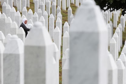 A Bosnian woman stands next to the gravestone of a relative before the mass funeral on the occasion of the 30th anniversary of the Srebrenica genocide at the Srebrenica-Potocari Memorial Center, Bosnia and Herzegovina.
