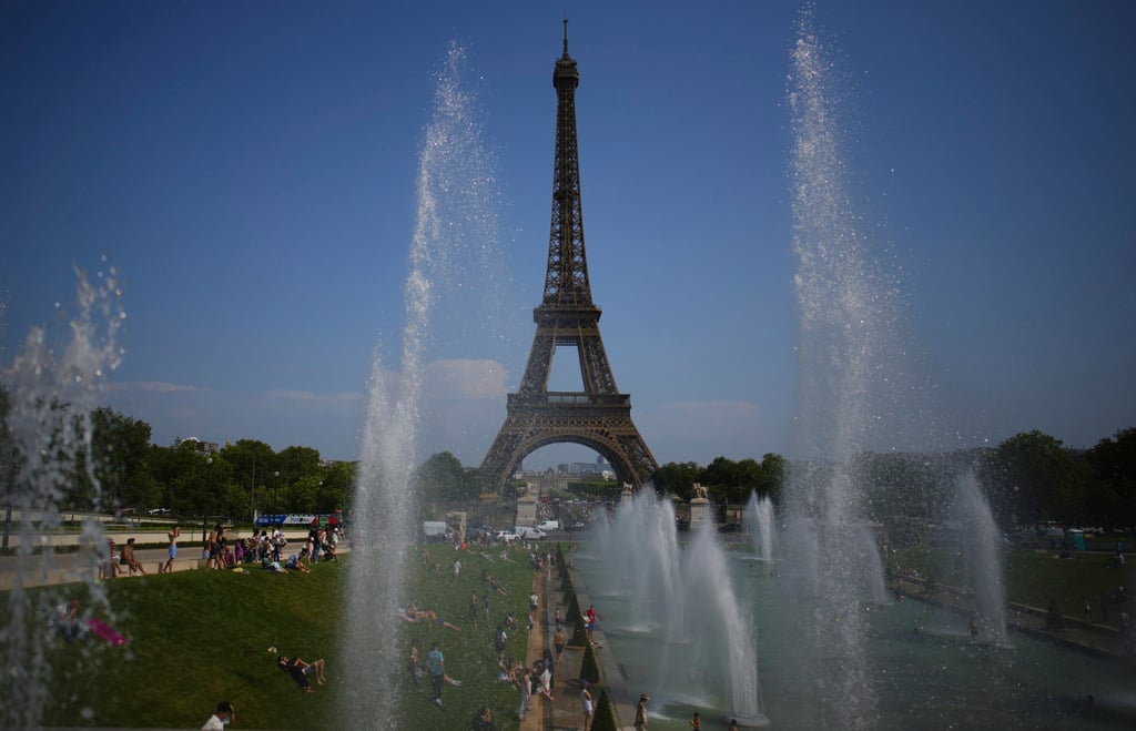 People cool off at a fountain at Trocadero near Eiffel Tower during a heatwave on July 2 in Paris. Photo: AP People cool off at a fountain at Trocadero near Eiffel Tower during a heatwave on July 2 in Paris. Photo: AP