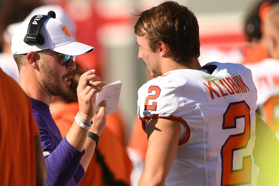 Clemson Tigers offensive coordinator Garrett Riley talks with quarterback Cade Klubnik (2) on the sideline.Ken Ruinard-Imagn Images