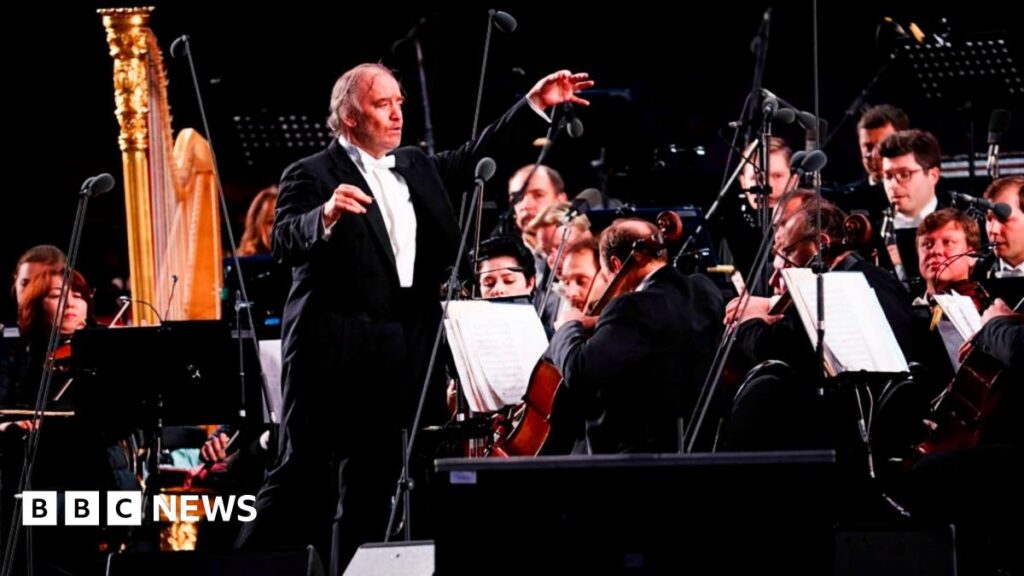 Russian conductor and Mariinsky Theater Artistic Director Valery Gergiev is surrounded by classical musicians on stage in Moscow in 2018.