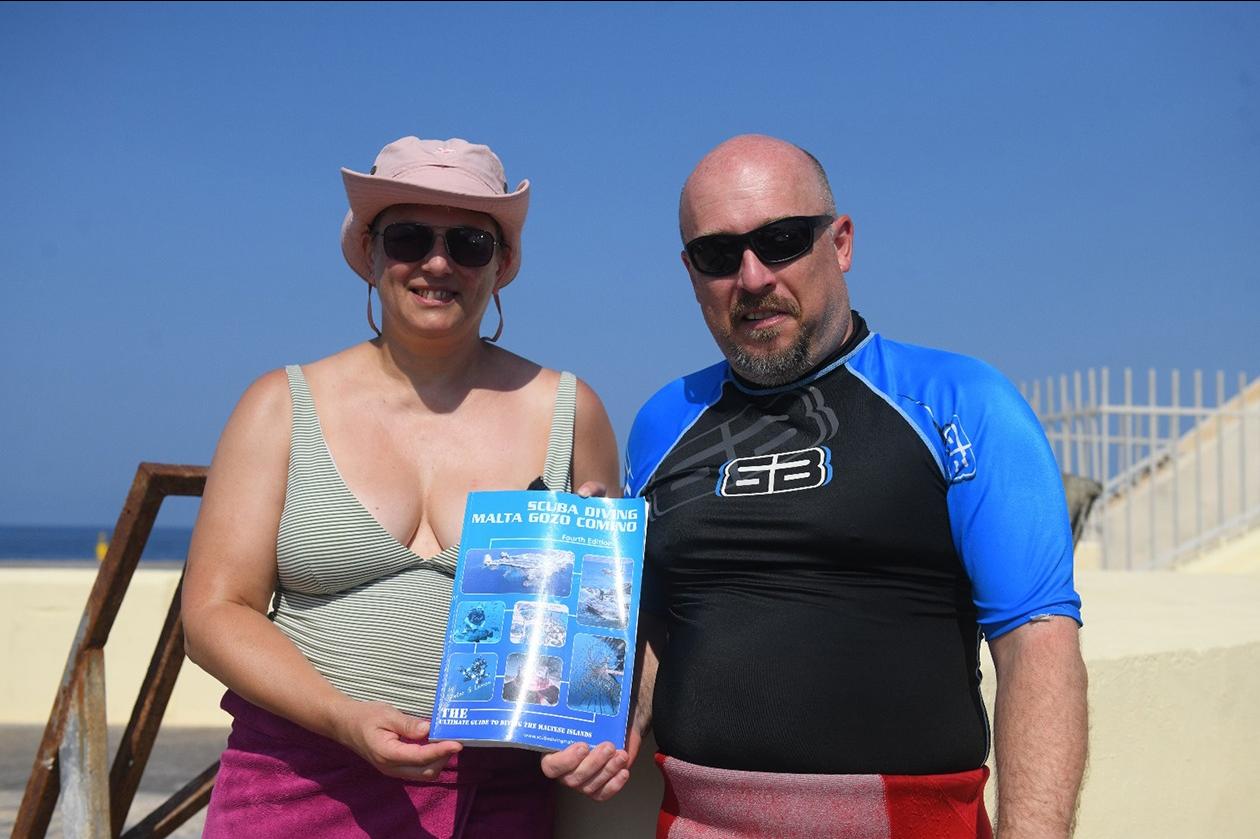 Divers Christina Woodcock and Chris Jiggens with Peter Lemon’s book. Photo: Matthew Mirabelli