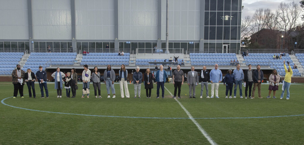 faculty members stand on the field durning half time of the 2025 UNC Women's lacrosse Educator Appreciation game