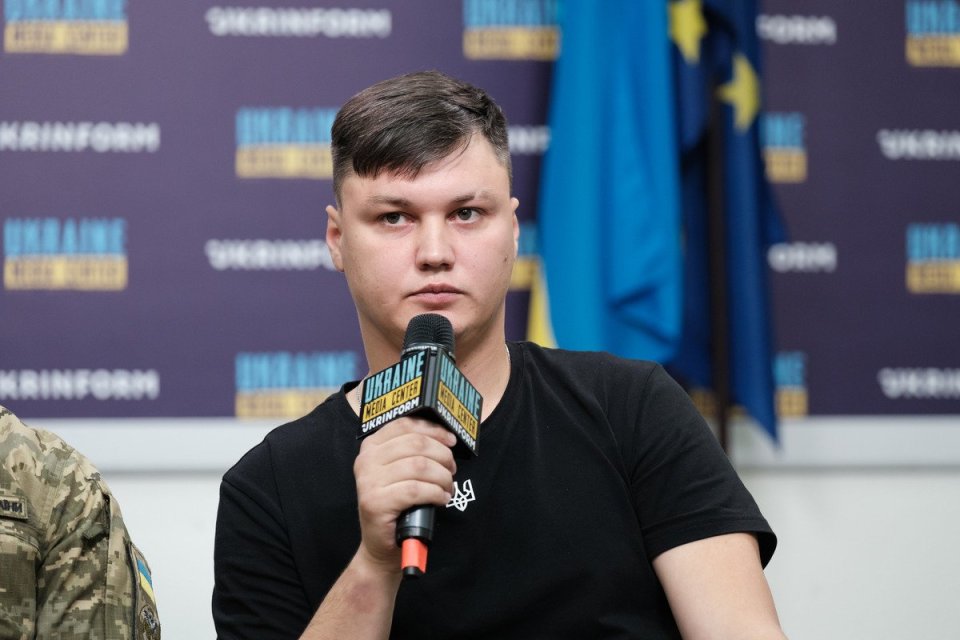 Man at press conference holding microphone.