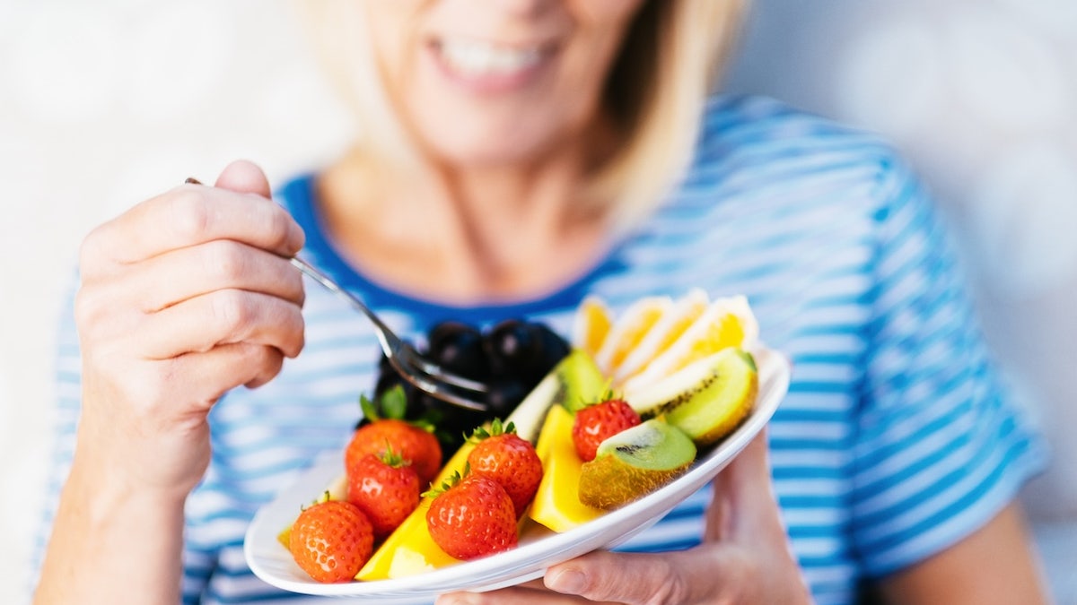 Older woman eating fruit