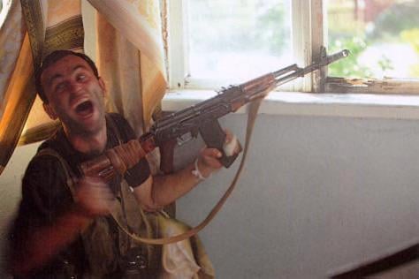 A Georgian fighter shouts in excitement after killing a sniper in the Abkhaz capital Sukhumi during the War in Abkhazia, 1993. [475x327]