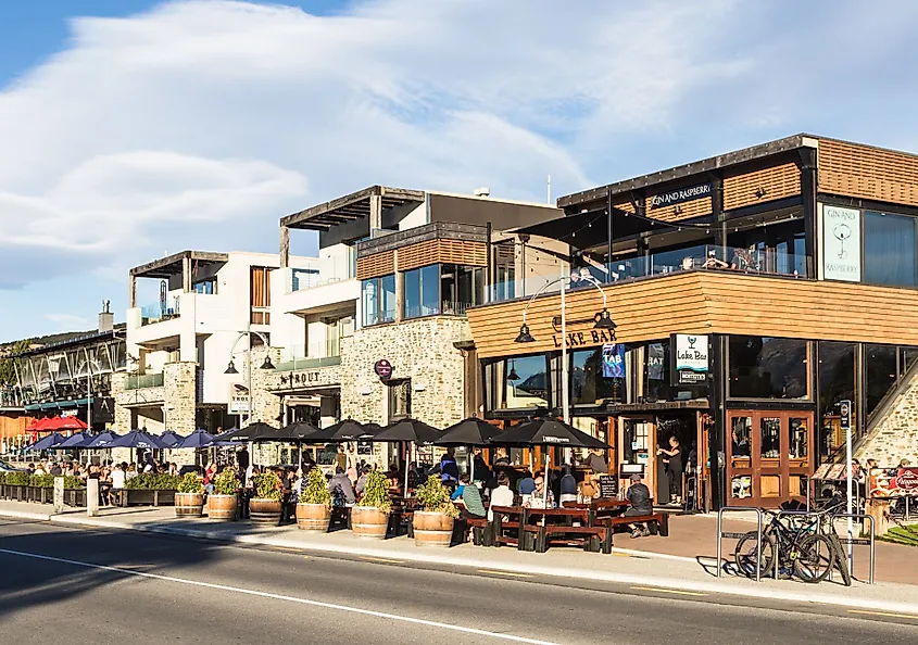 Tourists and locals enjoy a drink on the trendy sidewalk bar and restaurants in Wanaka lakefront in Wanaka, New Zealand