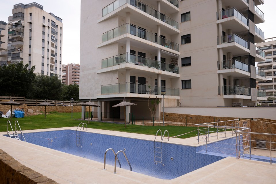 Empty swimming pool outside an apartment building.