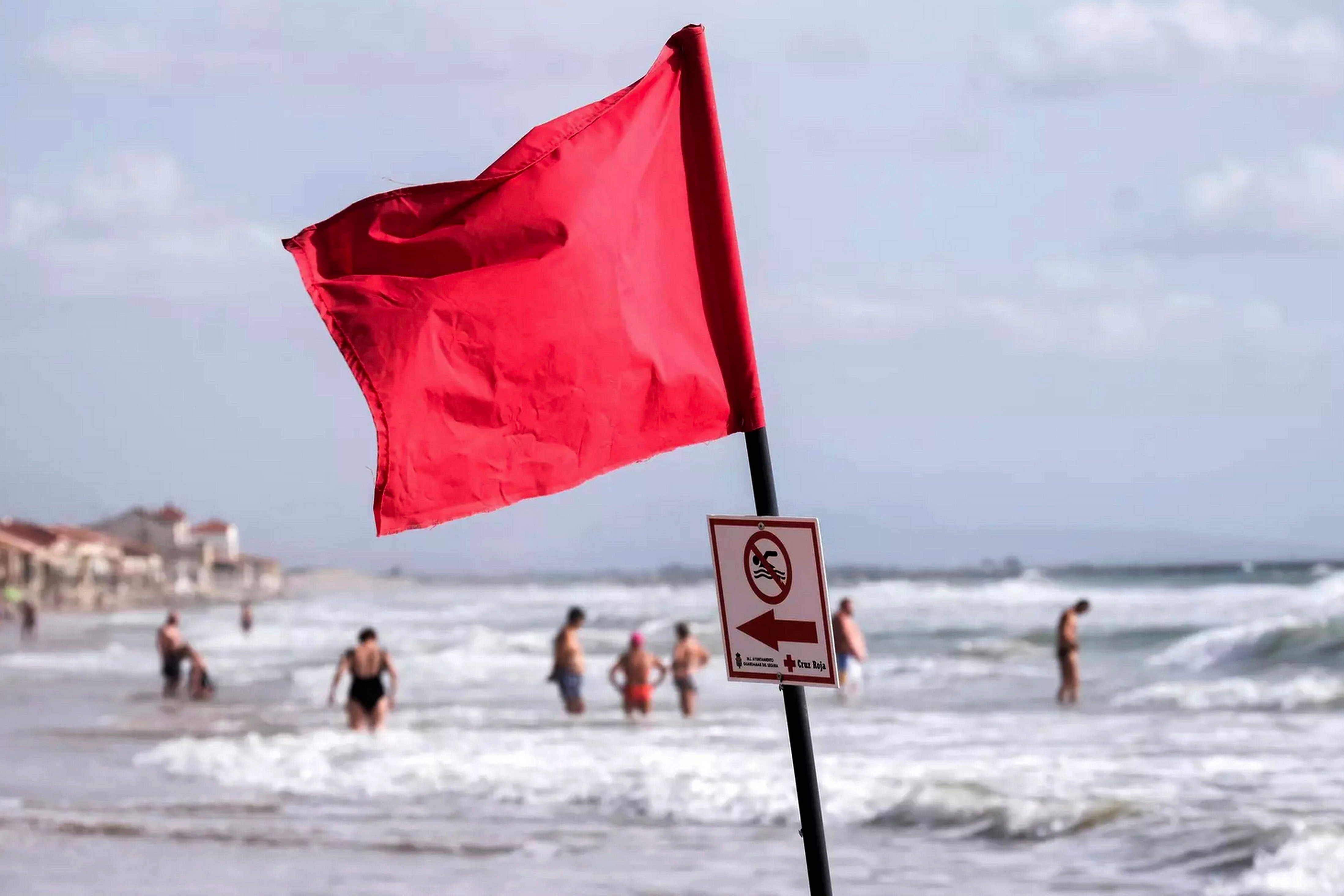 Red flag and no swimming sign on a beach.