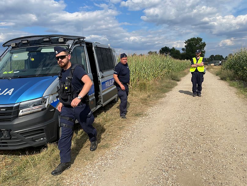 Police secure the area of a cornfield where an unidentified flying object crashed and exploded in the eastern part of the country in the town of Osiny, Poland.