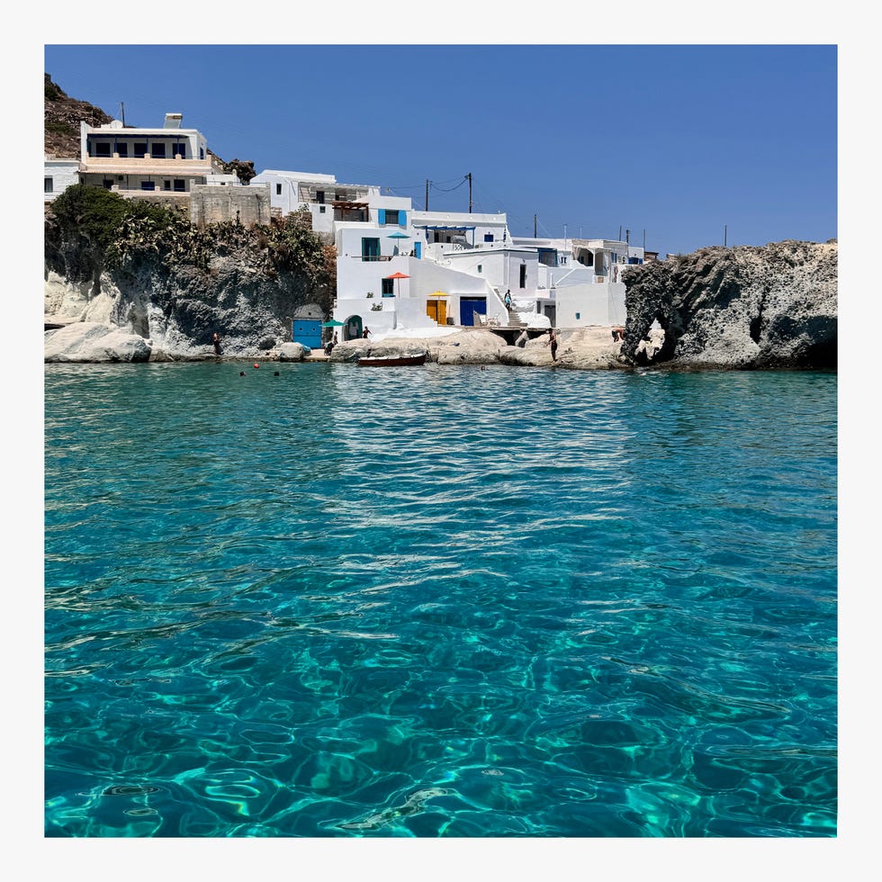 Coastal scene featuring traditional buildings by clear turquoise waters