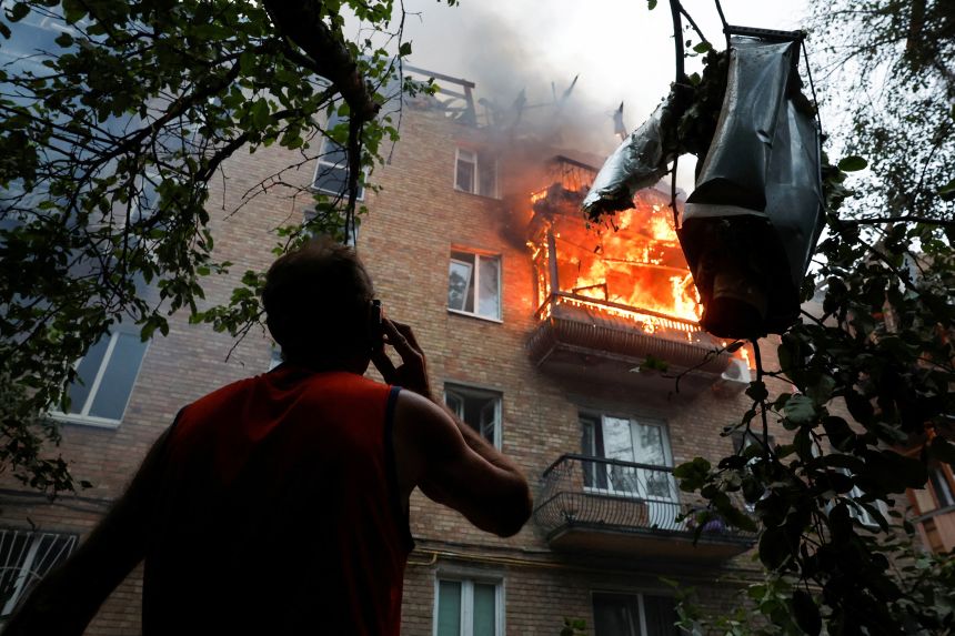 A resident looks on at the site of an apartment building hit during Russian missile and drone strikes in Kyiv, Ukraine, on July 3.