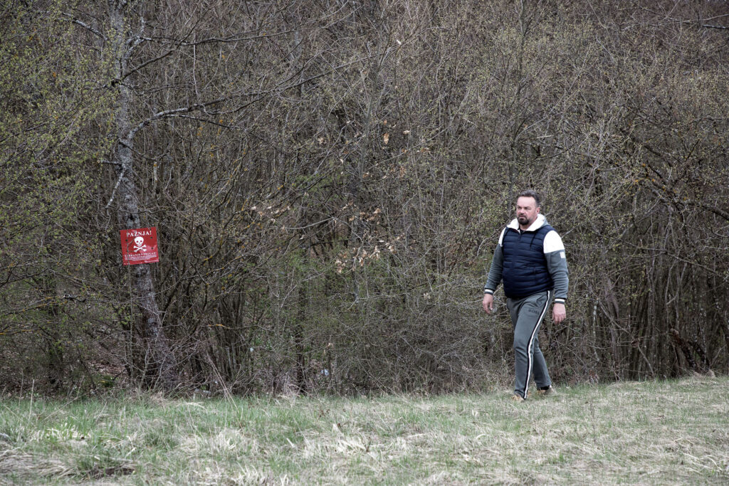 Nedzad, a local businessman and veteran from the 1990s war in Bosnia, walks along the edge of a mine-suspected area near Lipa migrant camp (Maryam Ashrafi)